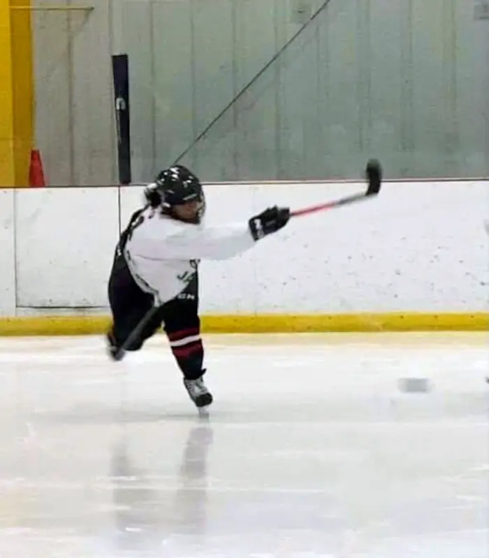 Selena Seto taking a slapshot on the ice