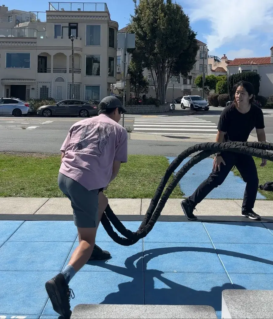 Selena Seto coaching a client through battle-rope training outdoors in San Francisco